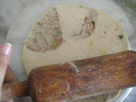 Roll it again to make a flat-bread with soft hands (as shown) with the help of a rolling pin. Do not exert pressure else the rajma might spill out of the packet.